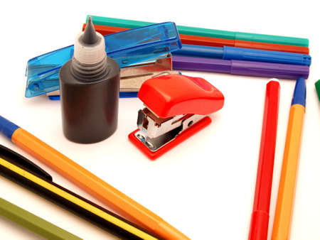 Felt-tip pens, stapler and paint on a white backgroundの写真素材