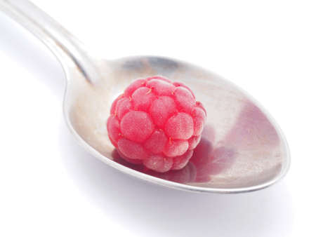 raspberries and spoon on a white backgroundの写真素材