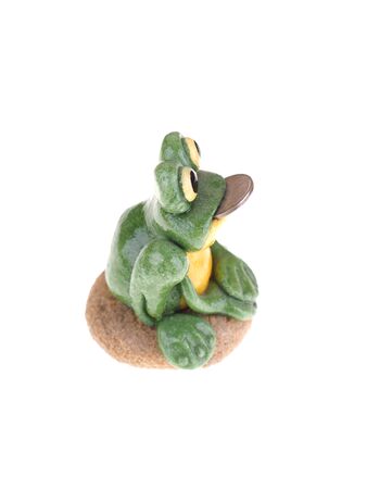 toy frog with a coin in his mouth on a white backgroundの写真素材