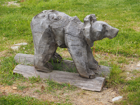 wooden figurine of a bear on the grassの写真素材