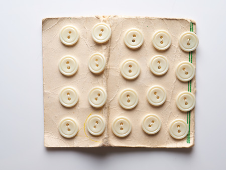 White buttons for clothes on a gray background