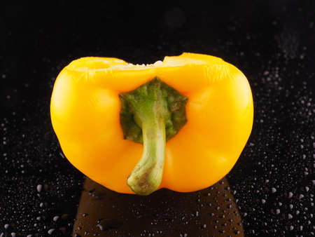 Yellow pepper on a dark background with dropletsの写真素材