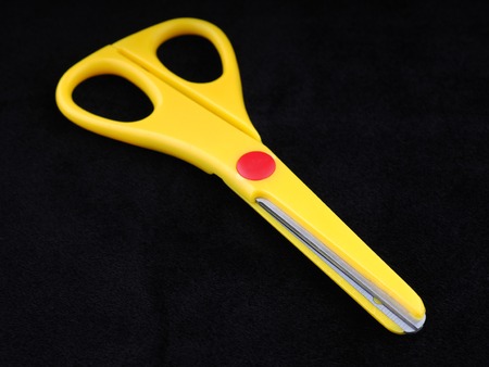 yellow scissors on a black backgroundの写真素材