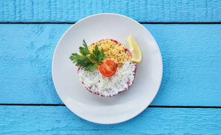 Salad with crab sticks on blue wooden background