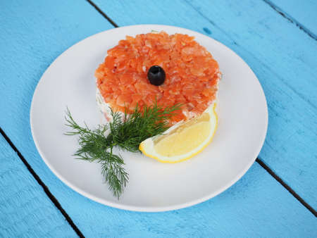 Red fish salad on blue wooden background