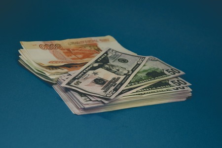 a pack of Russian rubles and dollars. two wads of money on a blue background. wealth of opportunity. success.の写真素材