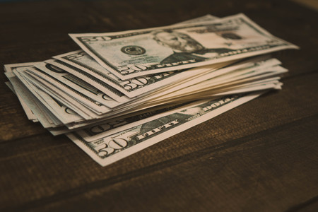 Dollar banknotes are lying at wooden backgroundの写真素材