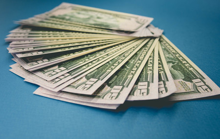 Pack of fifty dollars banknotes isolated on blue background.の写真素材
