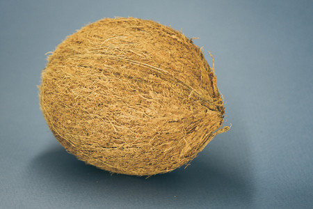 whole coconut lay on a dark blue background.の写真素材