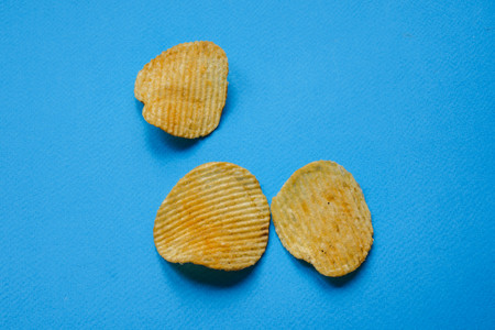 crispy potato chips on blue background. nachos chips.
