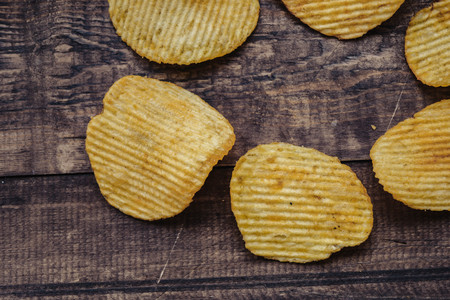crispy potato chips on wooden background. chips started.