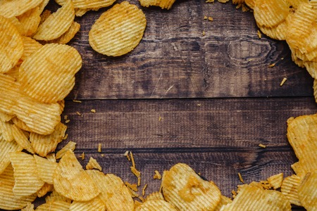 crispy potato chips on wooden background. chips started.