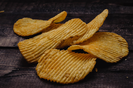 crispy potato chips on wooden background. chips started.