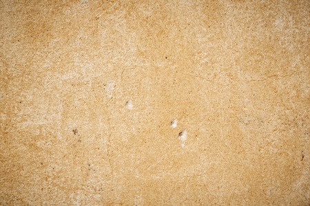 old beige wall with small holes in the wall.の写真素材