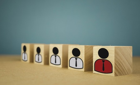 wooden cubes in the form of bosses and subordinates, personnel subordination on a blue background.