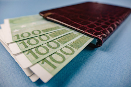 money in a leather wallet on a blue backgroundの写真素材