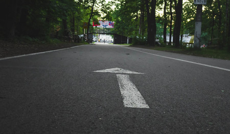 white arrow marked on the asphalt in the park, symbolizes the direction of movement.の写真素材