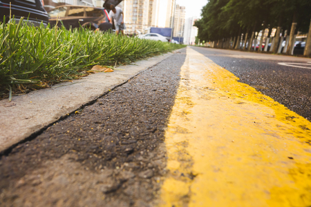 wet asphalt road with sun reflections and trees - instant vintage square photoの写真素材