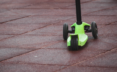 children's scooter on the playground in red.の写真素材