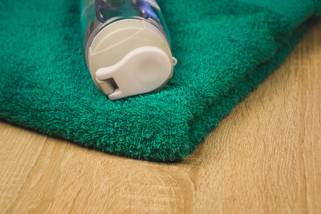 water bottle and turquoise towel on wooden backgroundの写真素材