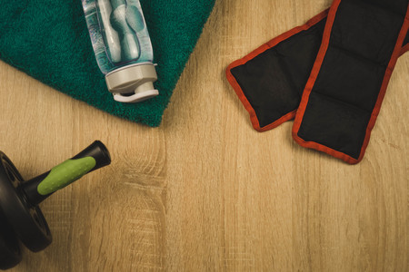 towel a bottle of water red weighting and a roller for the press on a wooden table.の写真素材