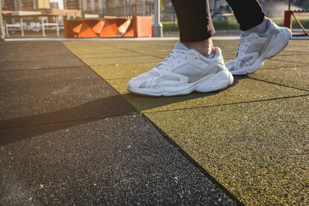 male legs shod in white sneakers on the playgroundの写真素材