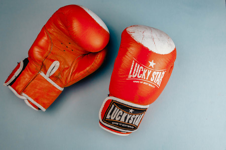 Russia Voronezh 06.06.2019 red faded boxing gloves on blue background