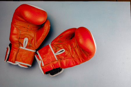 red faded boxing gloves on blue background.の写真素材