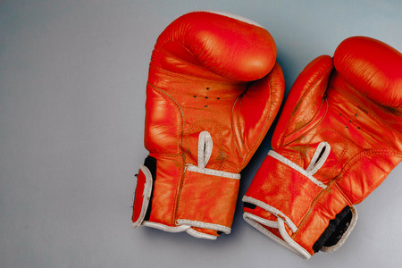 red faded boxing gloves on blue background.の写真素材