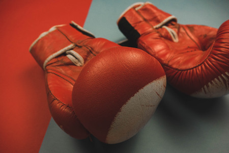 red boxing gloves on a red and blue backgroundの写真素材