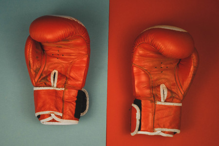 red boxing gloves on a red and blue backgroundの写真素材
