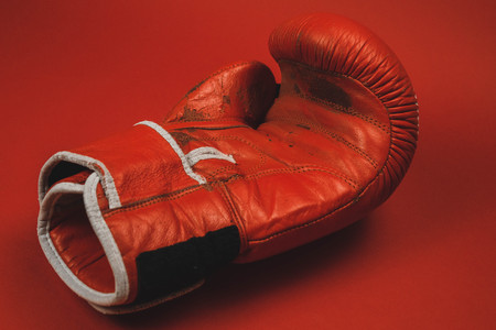 red faded boxing gloves on red backgroundの写真素材
