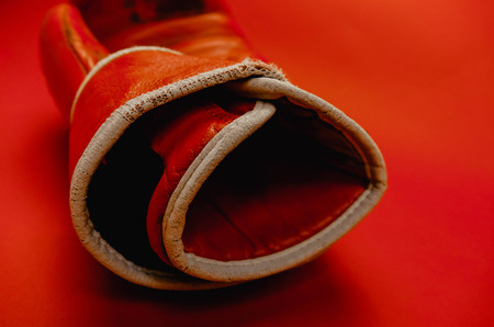 red faded boxing gloves on red backgroundの写真素材
