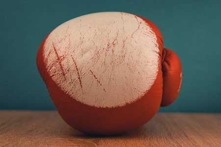 red boxing gloves on blue wooden background.の写真素材