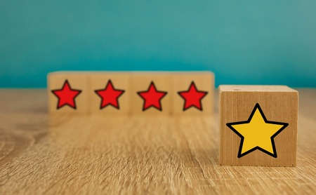 star icon yellow and red on wooden cubes far from blue background.の写真素材