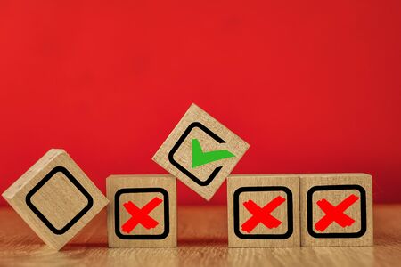 Wooden cubes with drawn marks on the red background.の写真素材