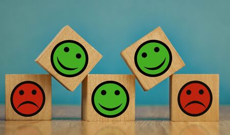 smiling and sad emoticons on a blue background. satisfaction concept.