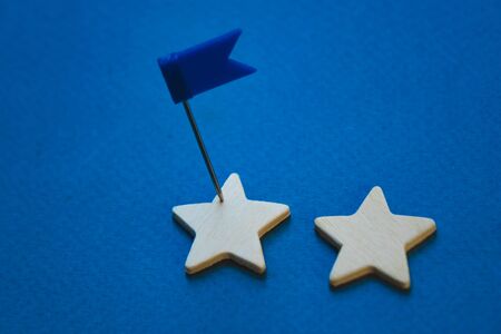 Wooden cubes in the form of a star with the flag placed in a row on a blue background.