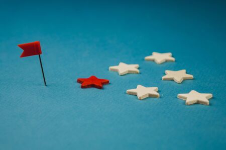 wooden stars and one red on a blue background with a red flag.の写真素材