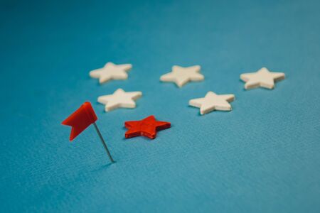 wooden stars and one red on a blue background with a red flag.の写真素材