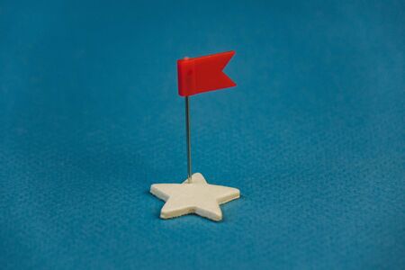 wooden stars and one red on a blue background with a red flag.の写真素材
