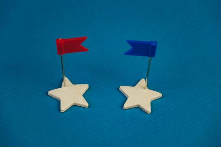 wooden stars and one red on a blue background with a red flag.の写真素材