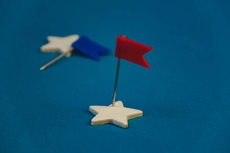 wooden stars and one red on a blue background with a red flag.の写真素材