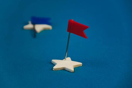 wooden stars and one red on a blue background with a red flag.の写真素材