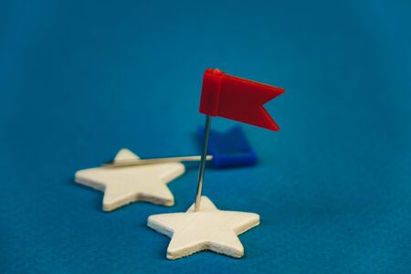 wooden stars and one red on a blue background with a red flag.の写真素材