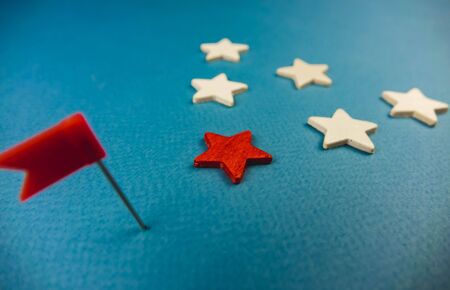 wooden stars and one red on a blue background with a red flag.の写真素材