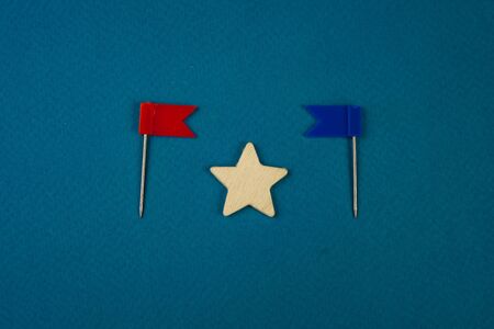 wooden stars and one red on a blue background with a red flag.の写真素材