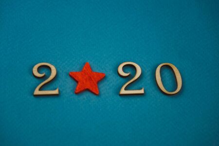2020 number from wooden numbers on a blue background with scattered stars gears and flags around.