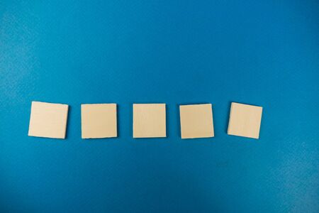 Five wooden block cube on a blue background. templateの写真素材
