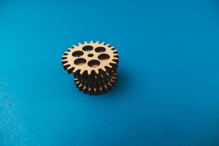 Wooden gear on a blue background. Abstract background for presentations and banners. The concept of technology and industry, the think process. Part of a large complex mechanism. Bannerの写真素材